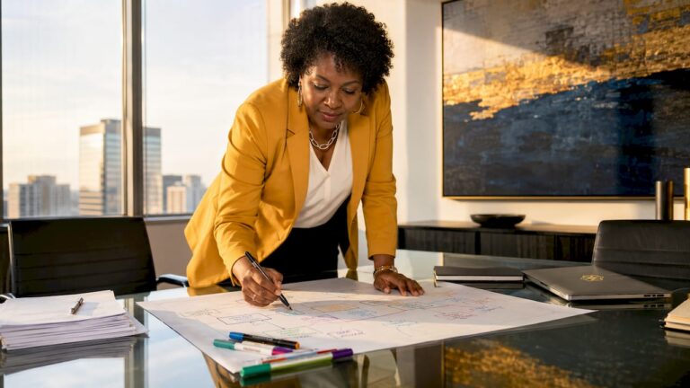 Businesswoman organizing workflow charts at desk
