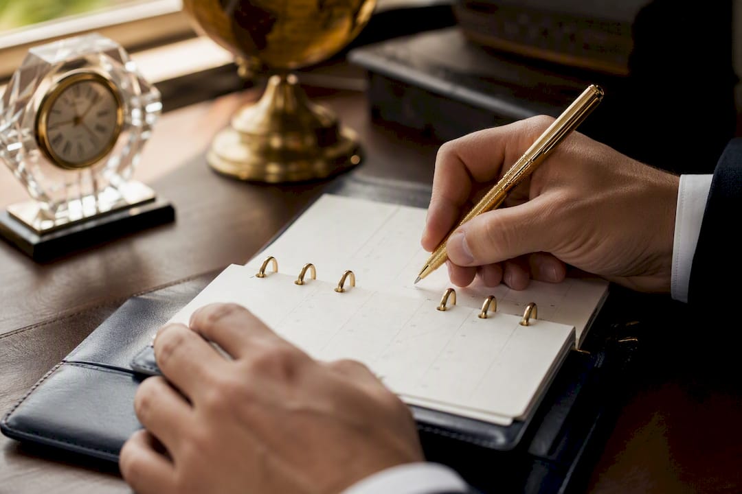 Hands marking calendar for cost to serve reviews