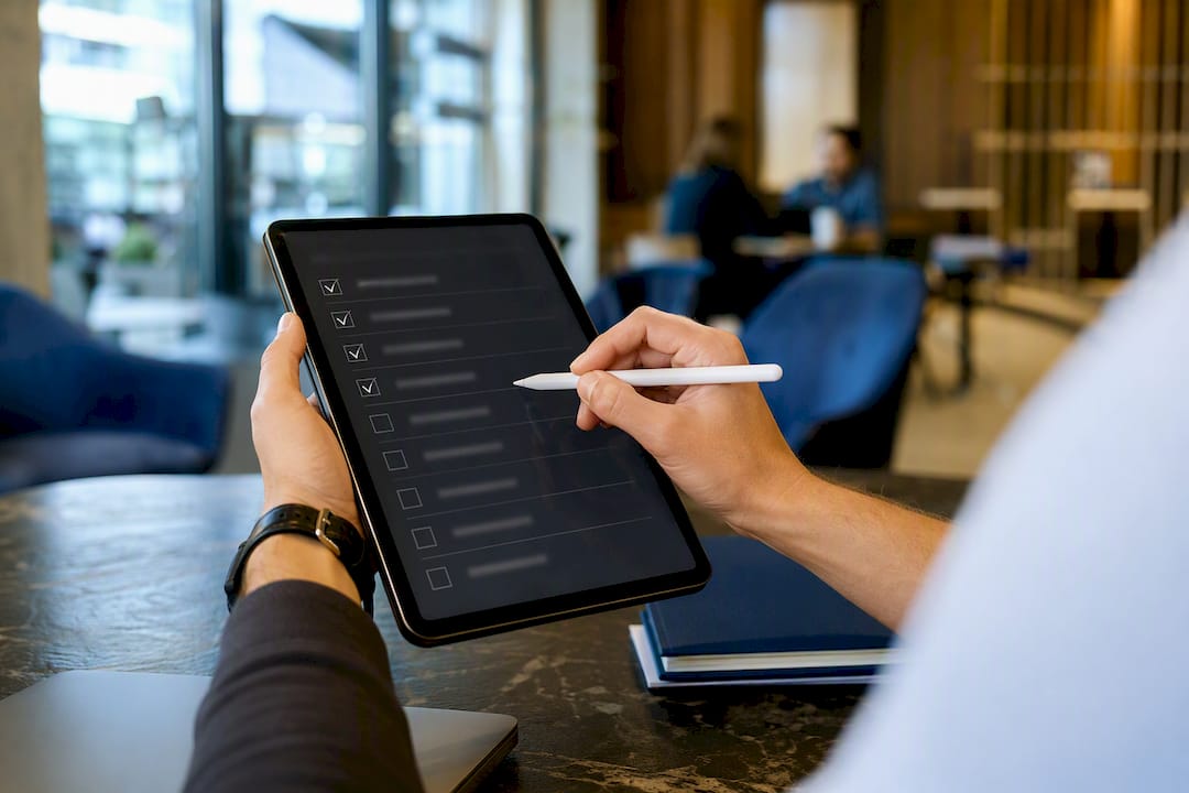 Hands checking delegation tasks on tablet